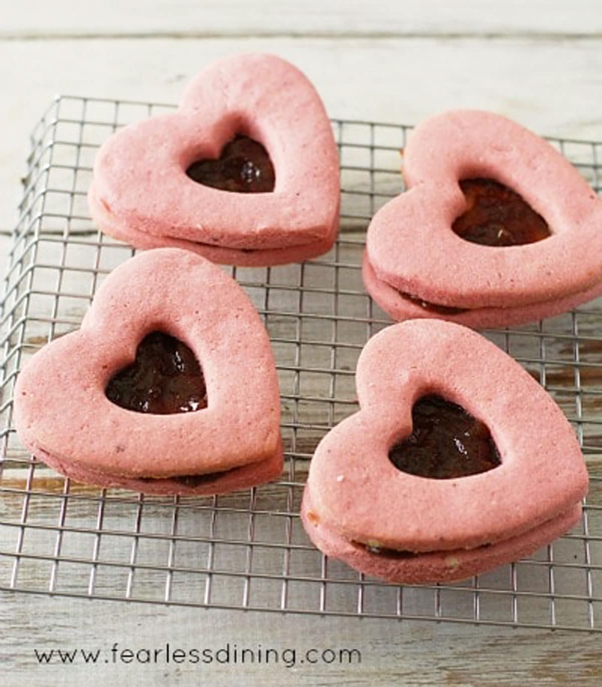 Heart shaped linzer cookies on a cooling rack.