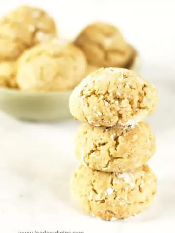 a stack of honey cookies next to a bowl of cookies
