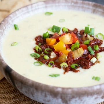 A close up of a bowl of stuffed white queso dip in a bowl.