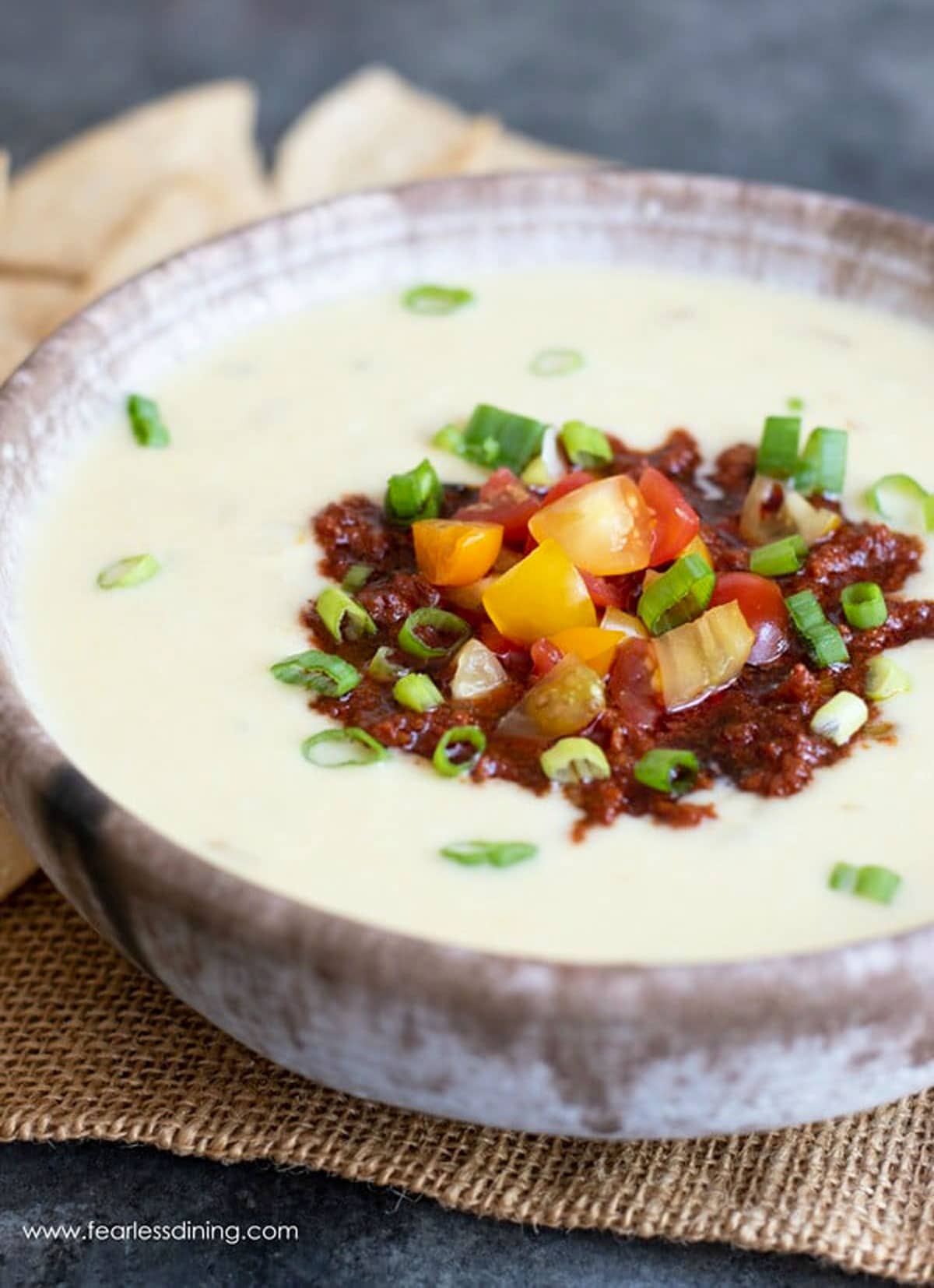 A close up of a bowl of stuffed white queso dip in a bowl.