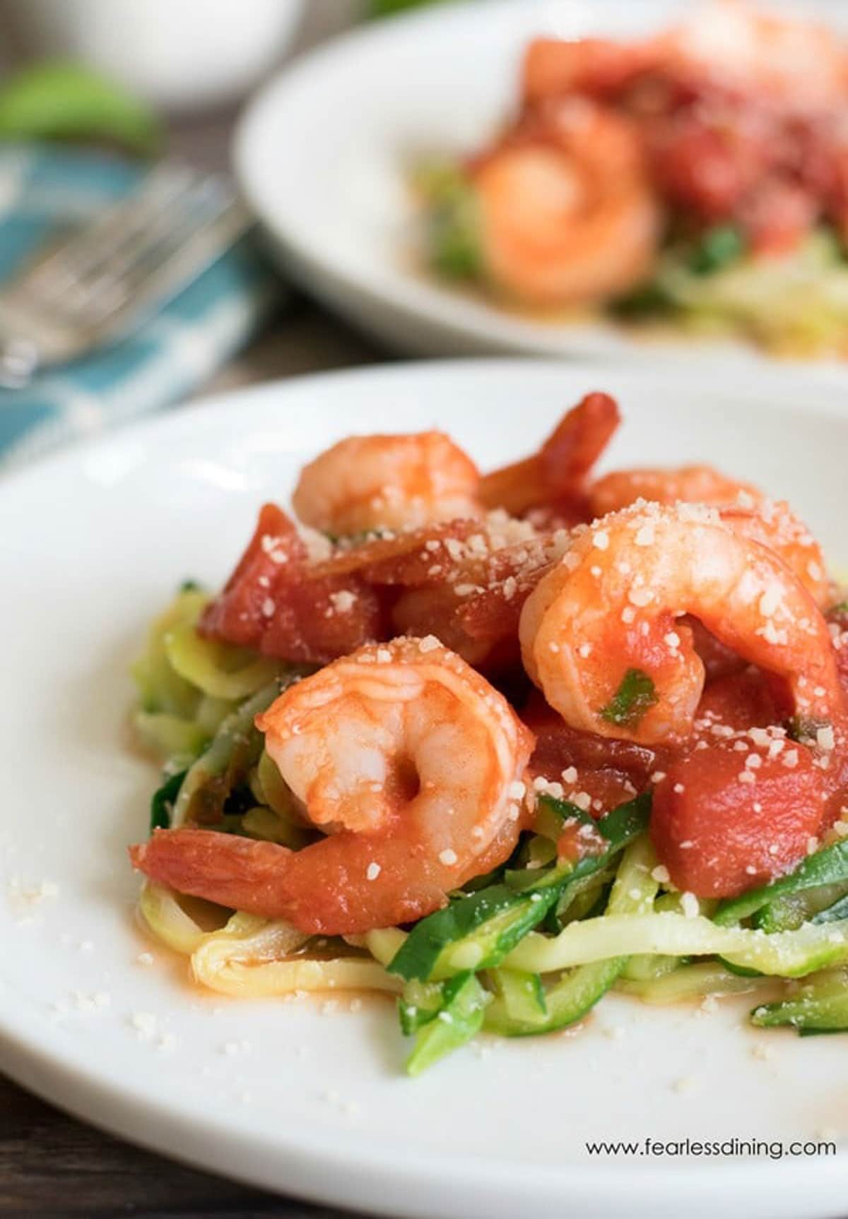 Two plates of shrimp diavolo over zucchini noodles.