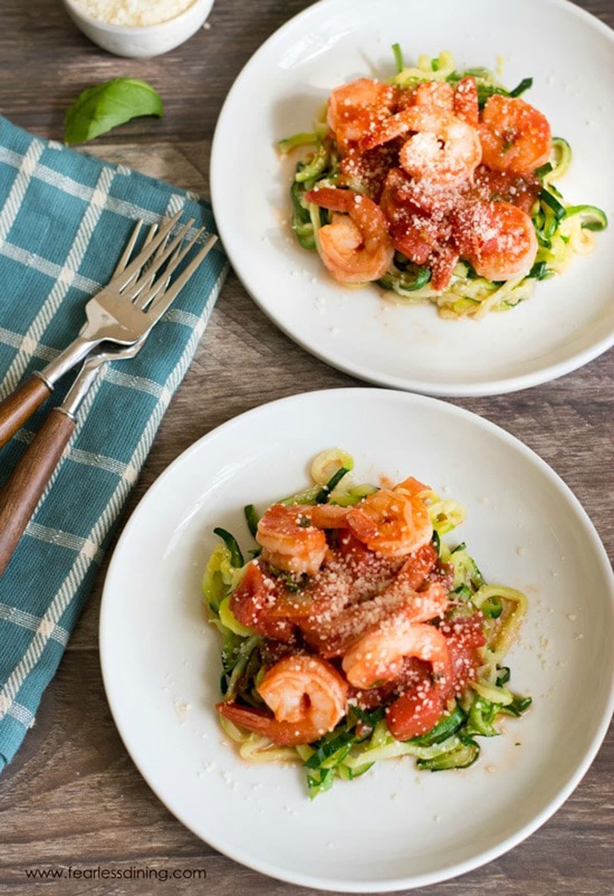 A top view of two plates of shrimp fra diavolo over zucchini zoodles.