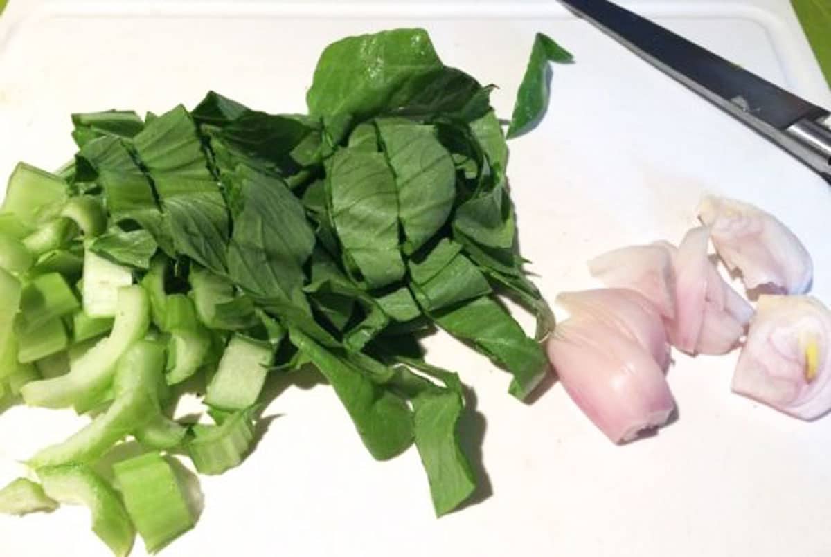 Bok choy and shallots on a cutting board.