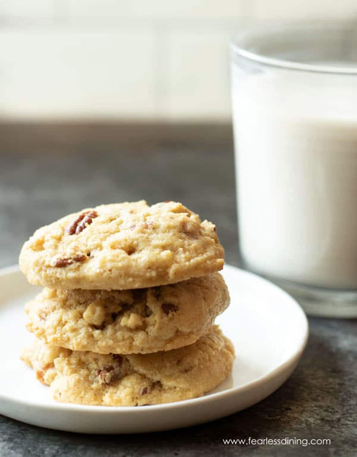 A stack of three cookies on a plate.