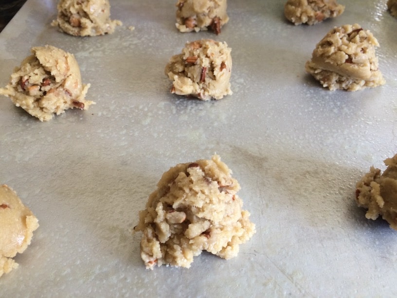 The pecan cookie dough balls on a cookie sheet.