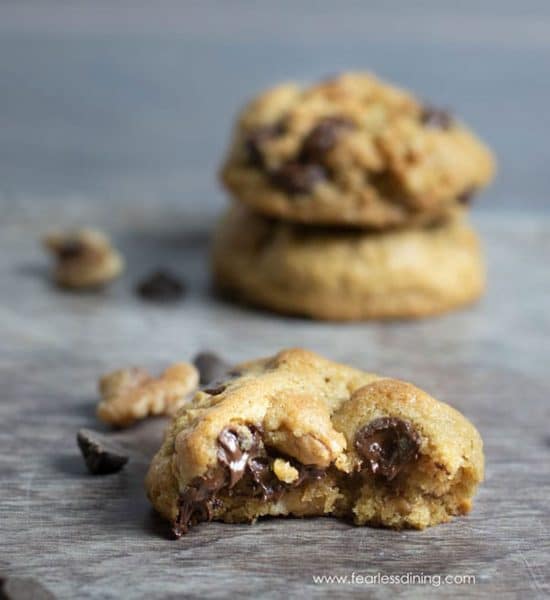 A chocolate chip cookie with a bite missing so you can see the melted chips inside.
