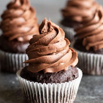 three frosted cupcakes on the counter