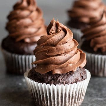 Rows of chocolate frosted cupcakes on the counter.