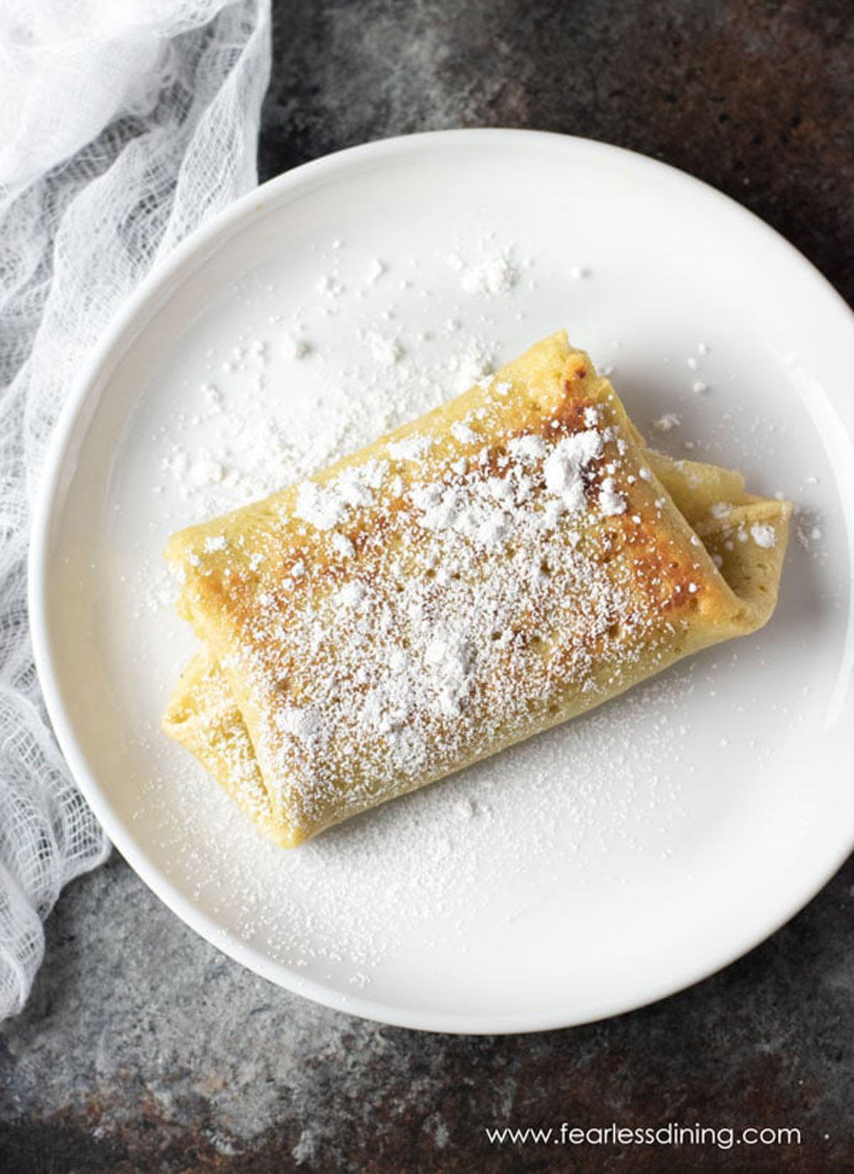 The top view of a cooked blintz dusted with powdered sugar.