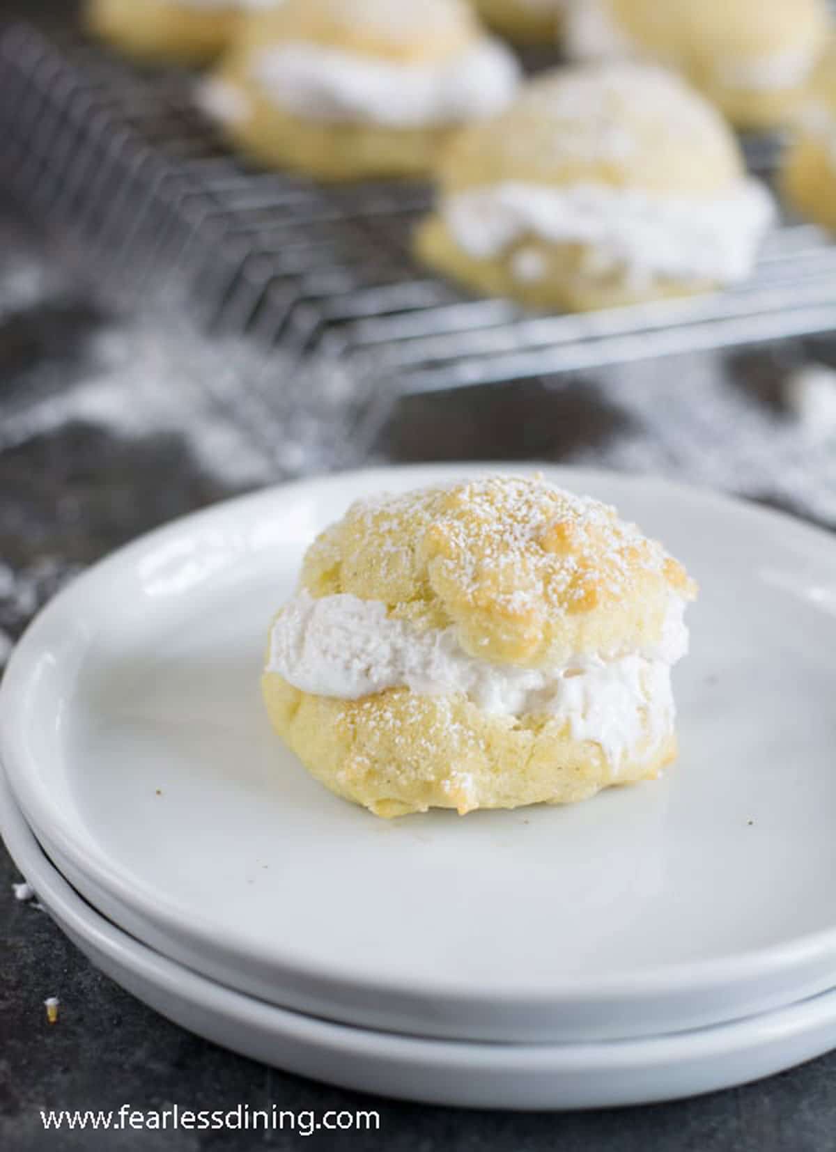 A filled cream puff on a white plate.