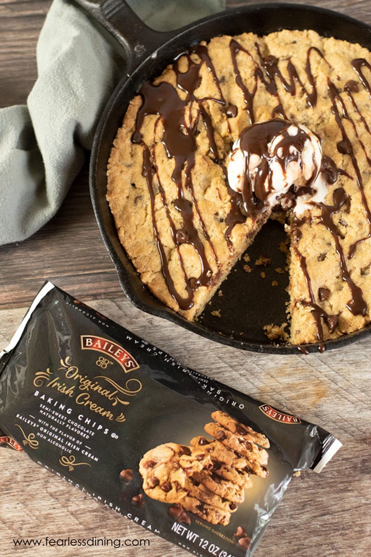 The top view of the baked skillet cookie next to a bag of chips.