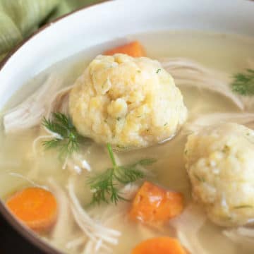 A close up of the gluten free matzo balls in a bowl of soup.