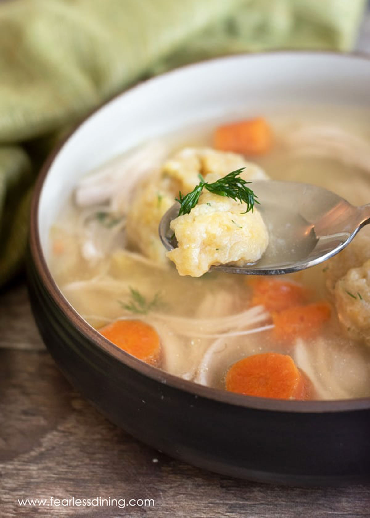 A spoon with a bite of matzo ball and broth.