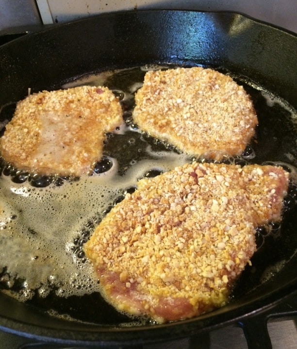 A photo showing the schnitzel frying in oil.