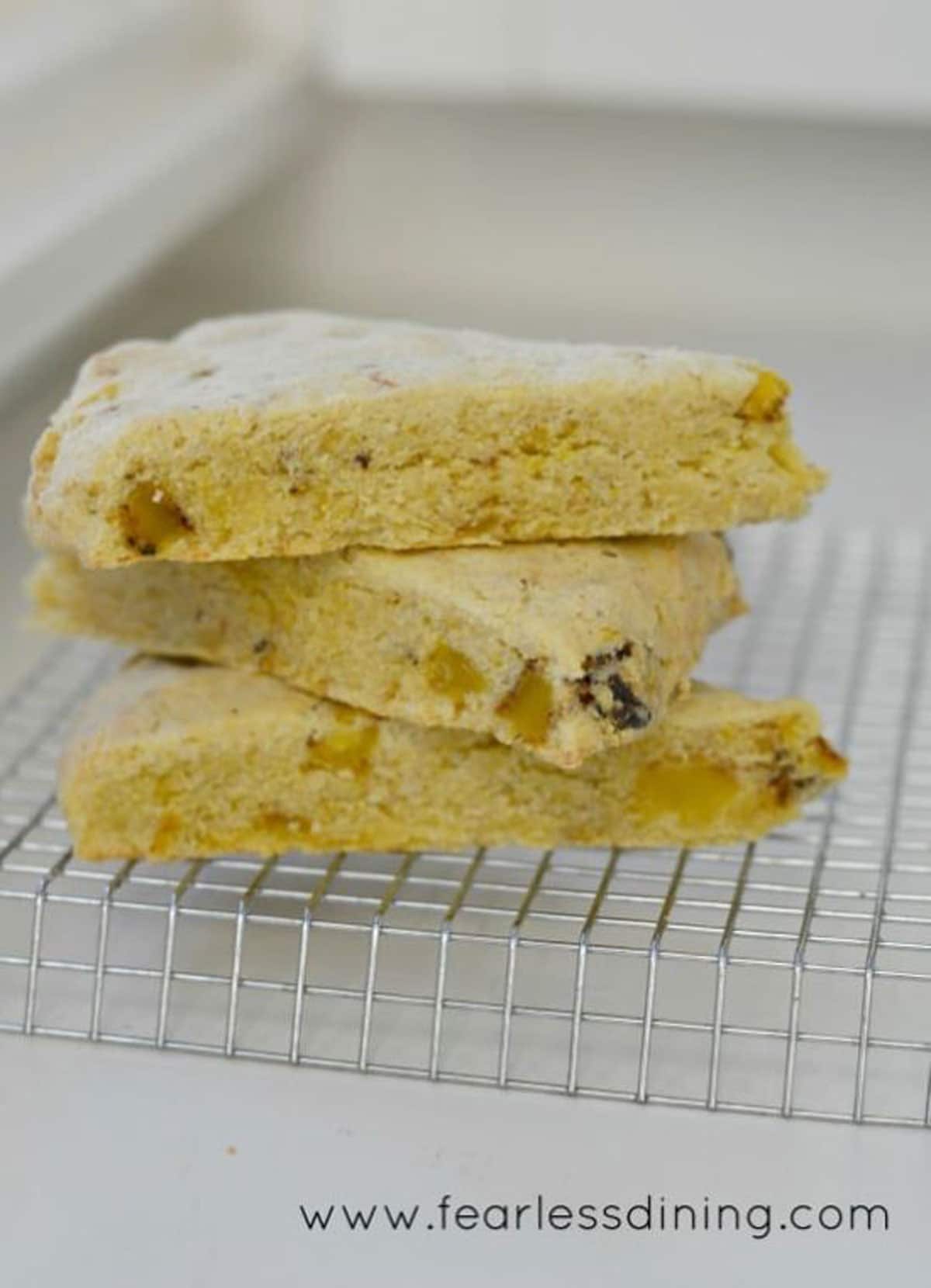 Three gluten free cornmeal scones stacked on the counter.