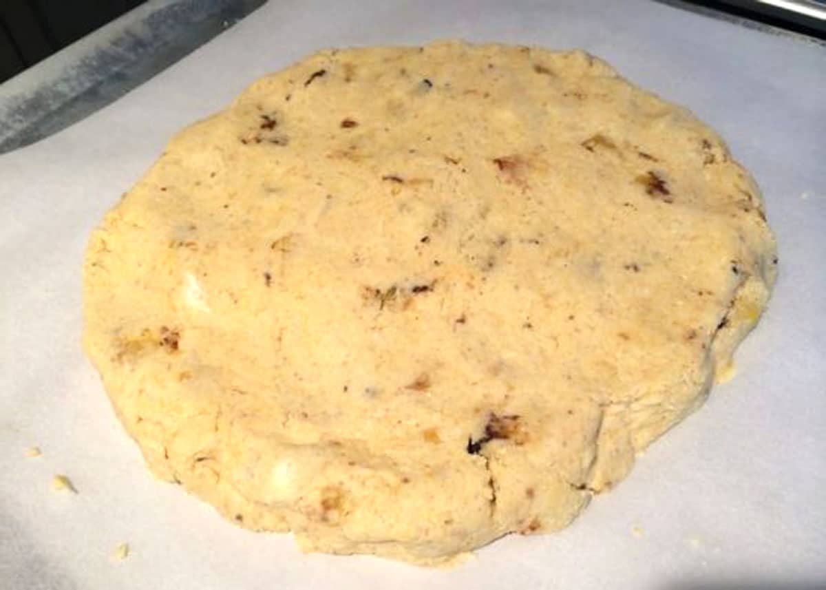 A round disc of shaped scone dough ready to score and bake.