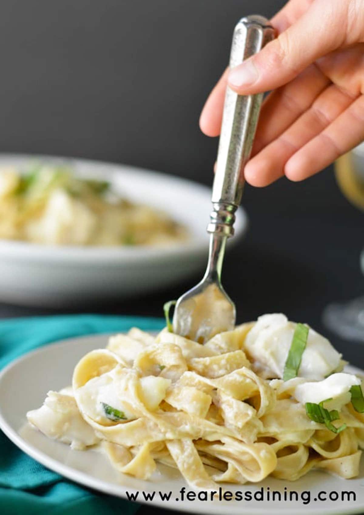 A fork twirling pasta from a plate.