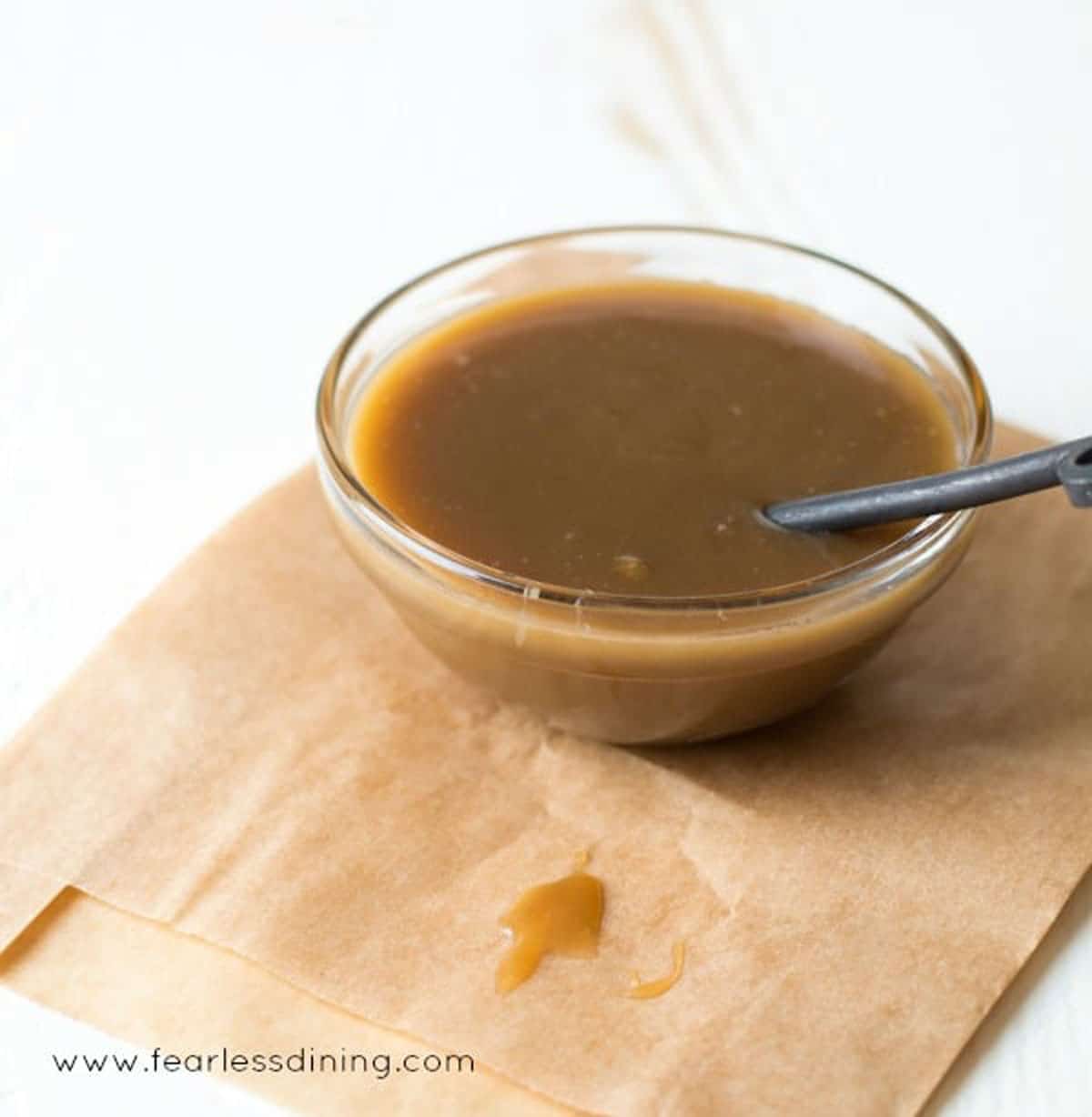 A small glass bowl filled with butterscotch sauce.