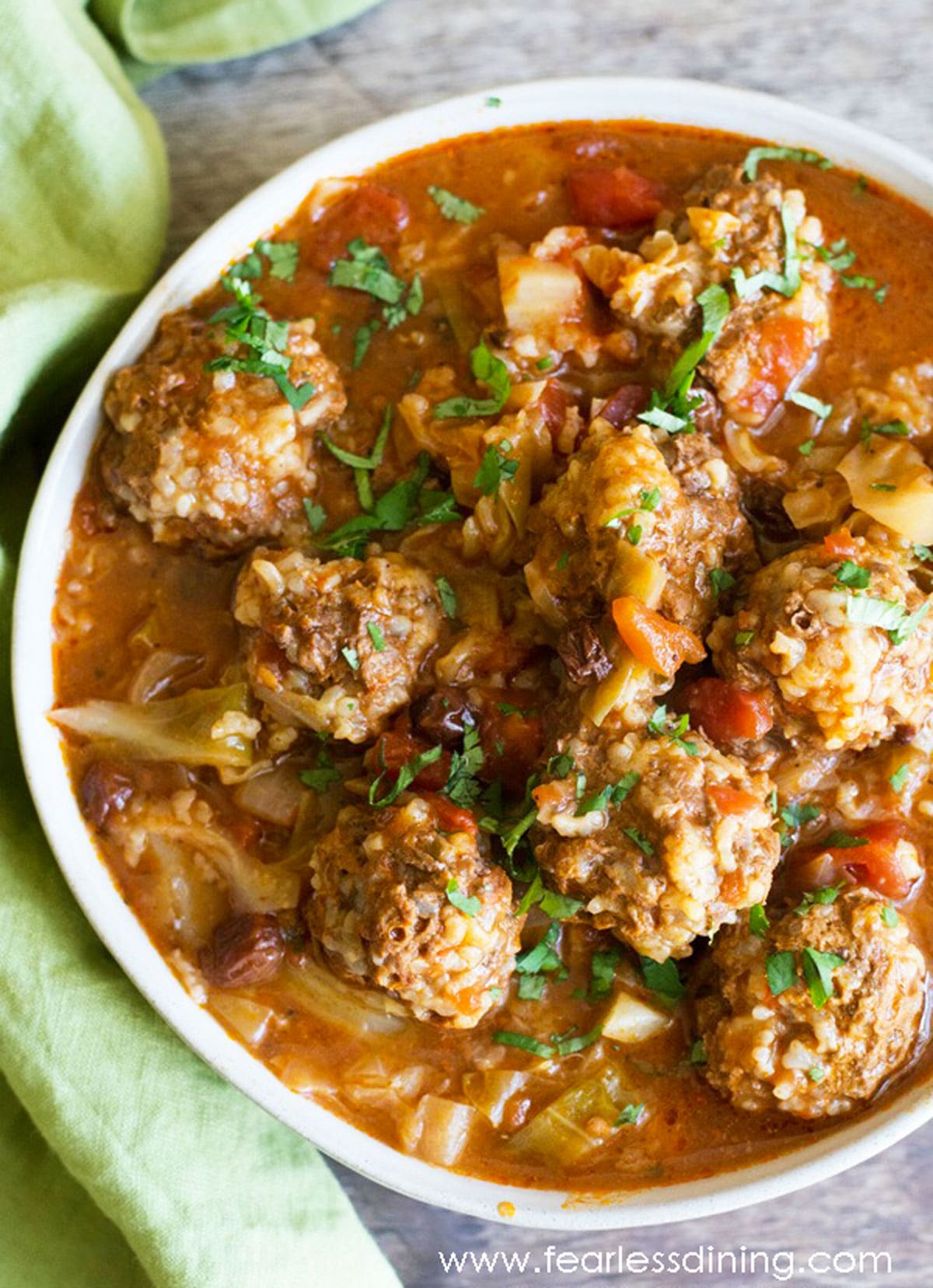 The top view of a serving dish filled with cabbage and meatballs.