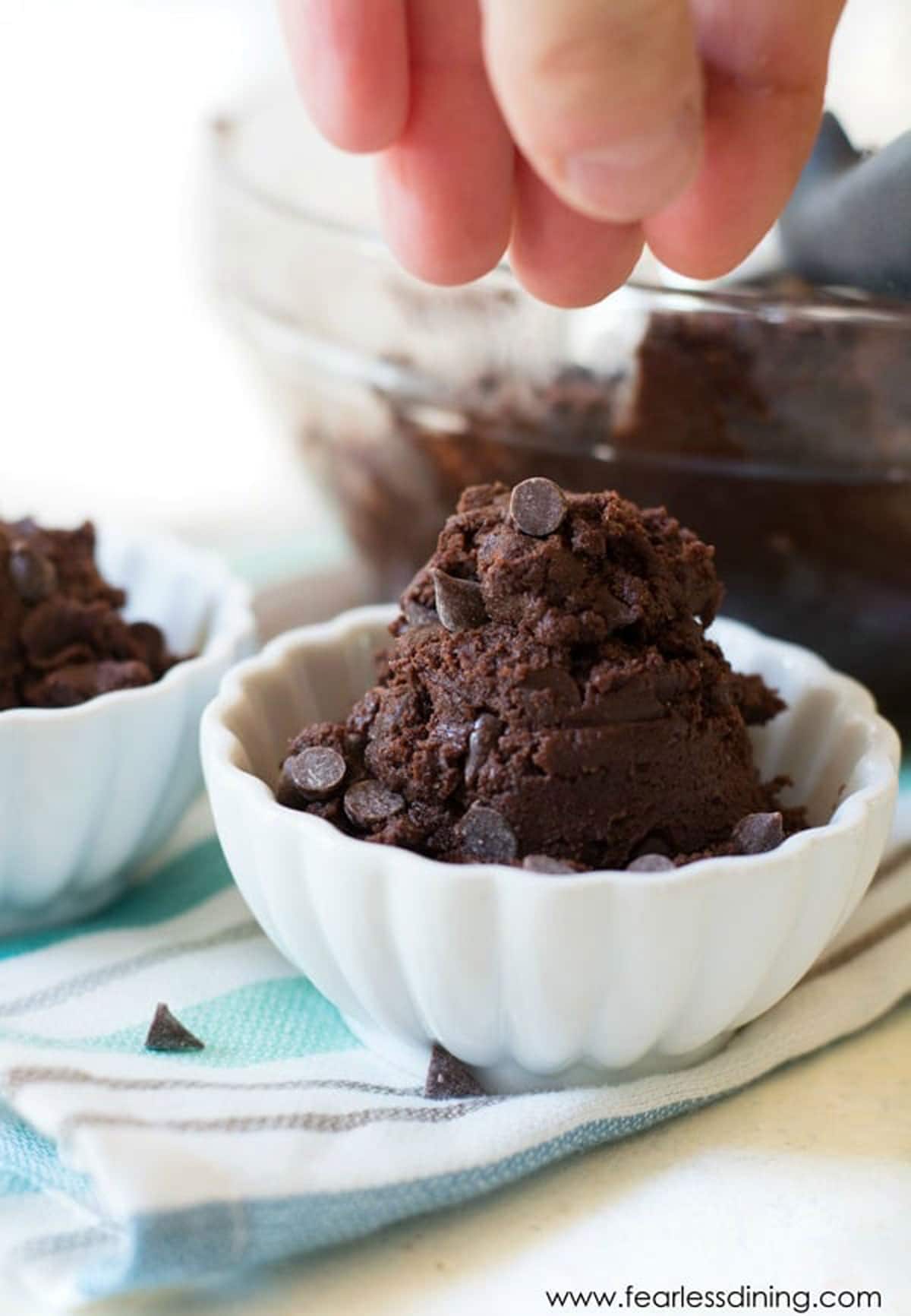 Sprinkling chocolate chips over the edible cookie dough.