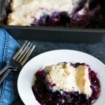 a small white plate filled with blueberry cobbler