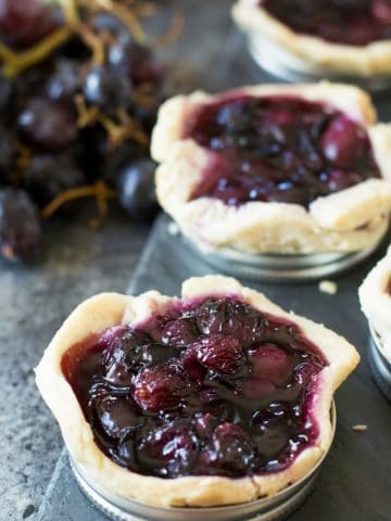 Grape galettes lined up on a slate serving dish.