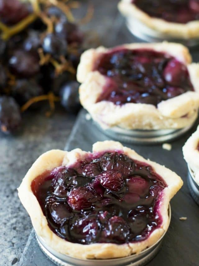 Grape galettes lined up on a slate serving dish.