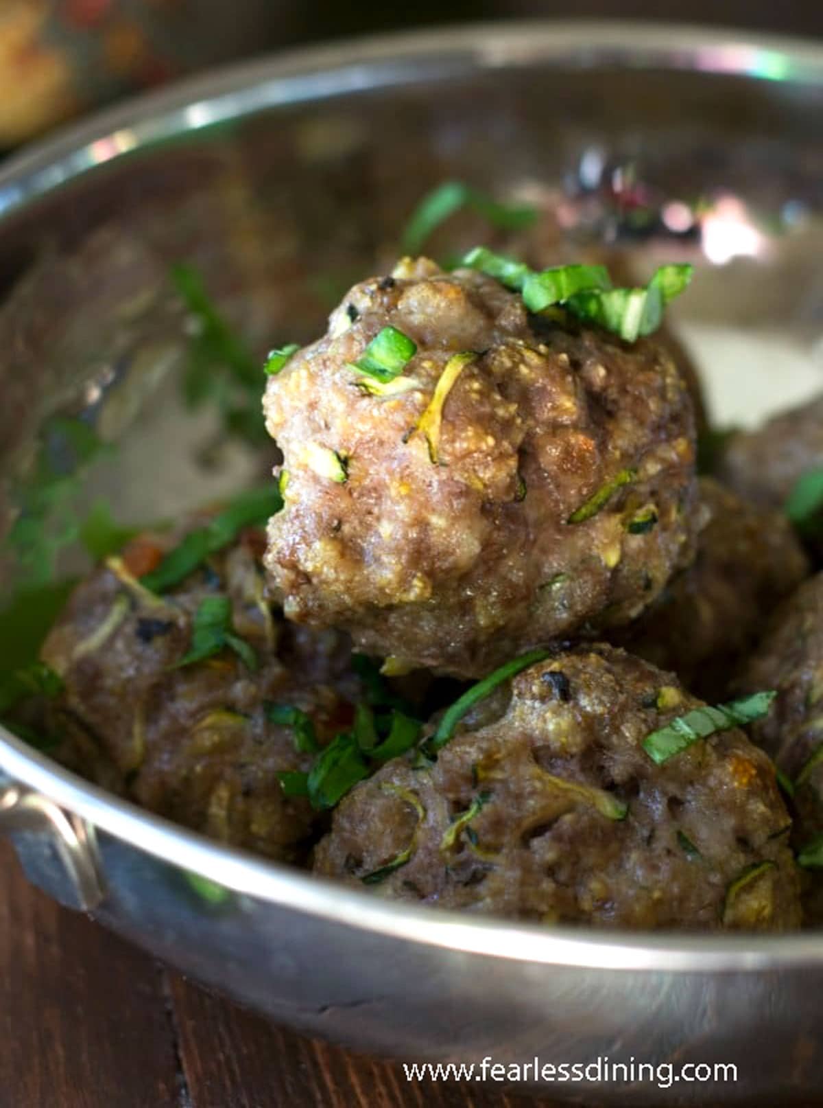 Cooked meatballs in a silver bowl.
