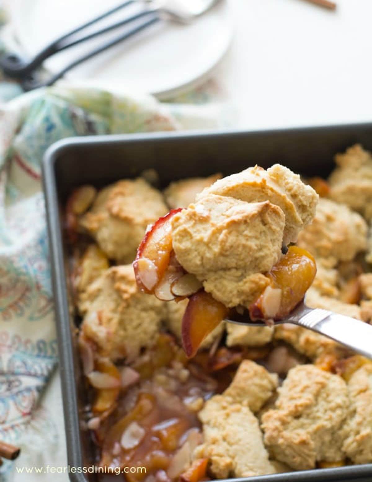 Scooping a serving of cobbler out of the pan.