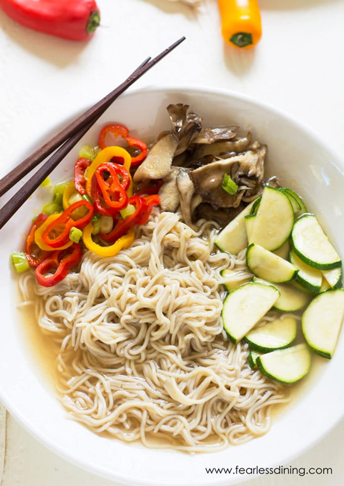 A bowl of ramen soup with vegetables.