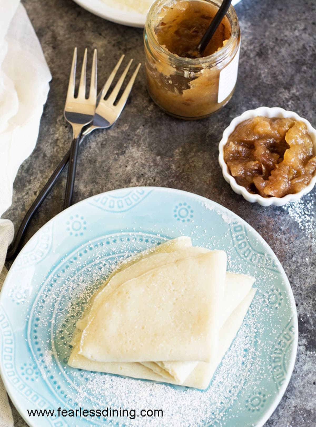 A light blue plate with folded crepes stacked on top.