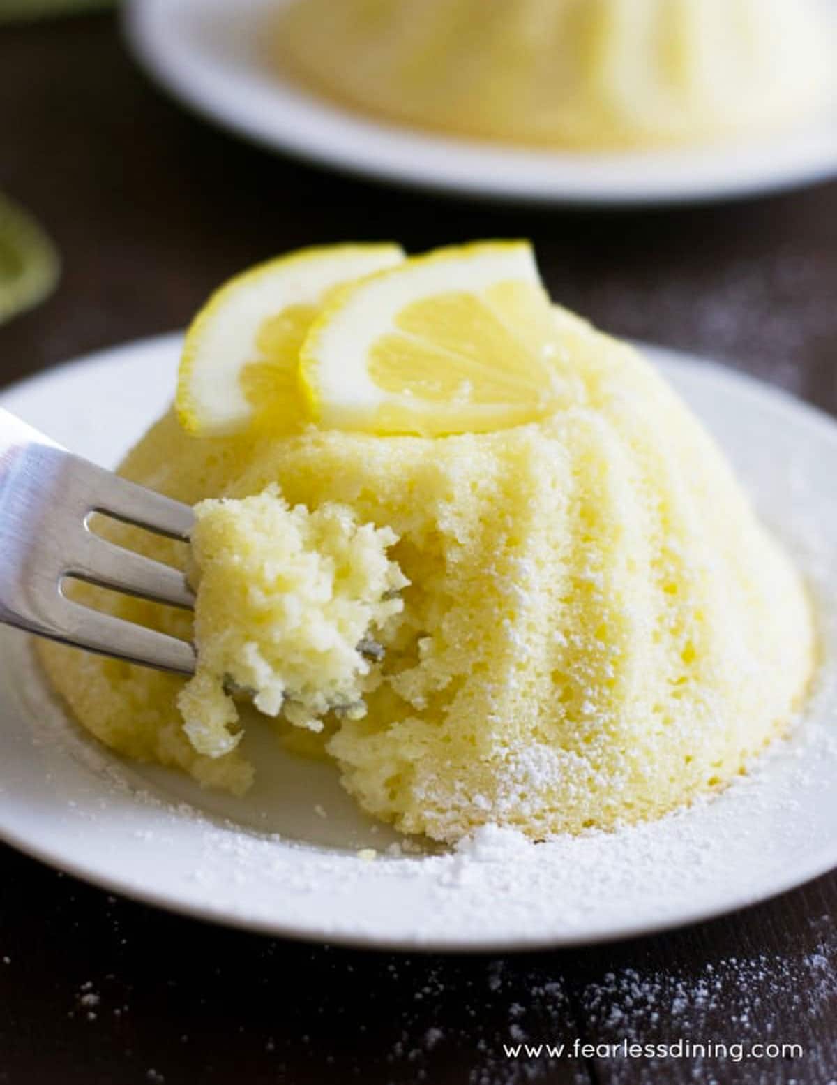 a fork cutting into a small lemon yogurt cake