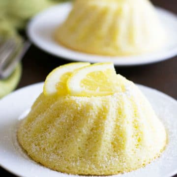 Lemon gluten free yogurt cakes on little white plates.