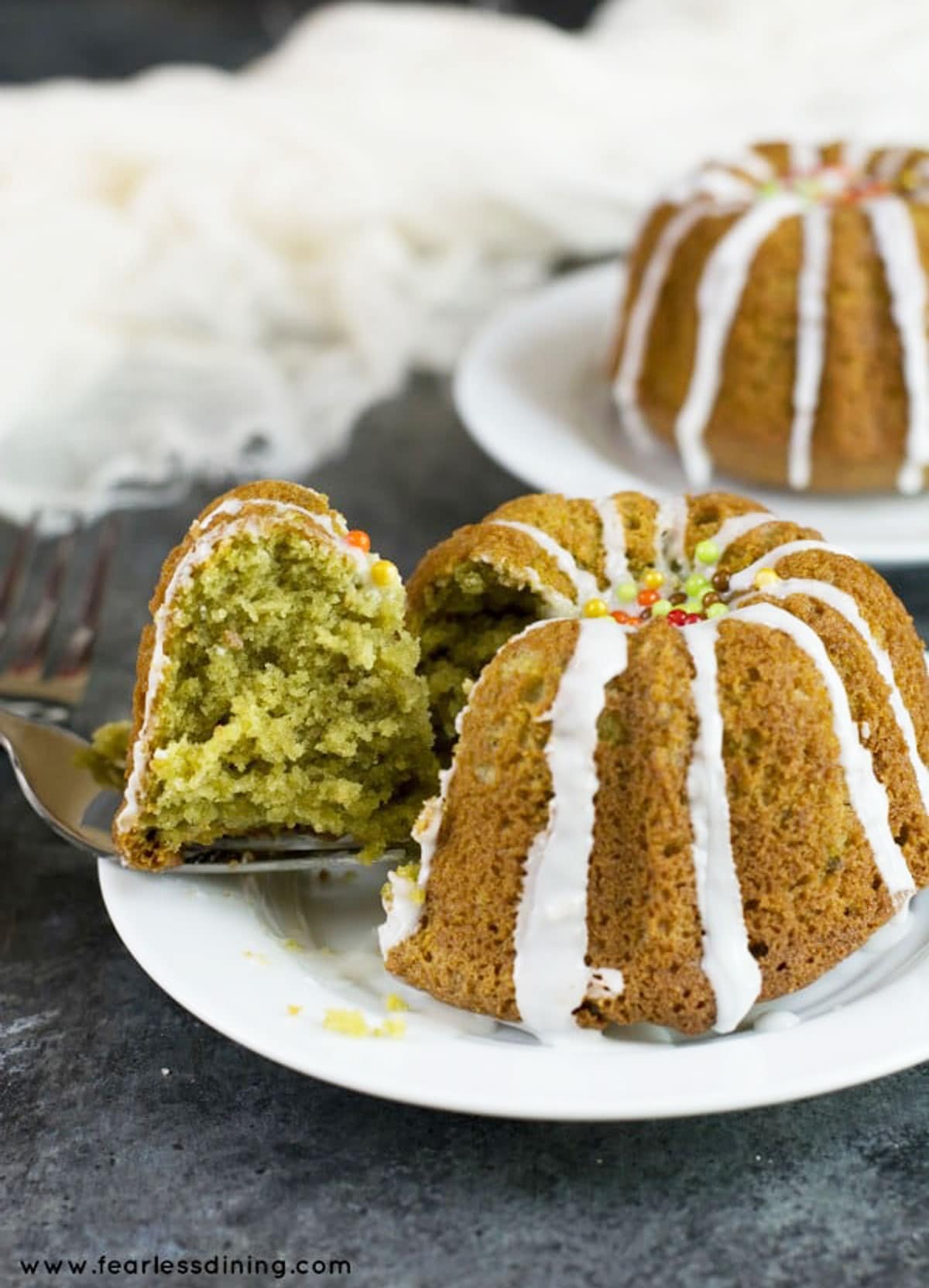 S slice of matcha bundt cake being cut from the main cake.