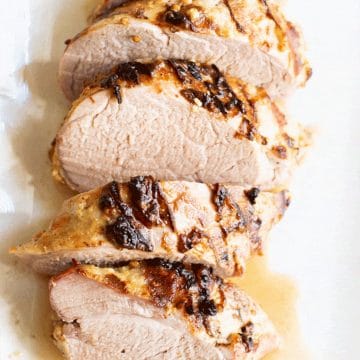 A sliced pork tenderloin on a cutting board.