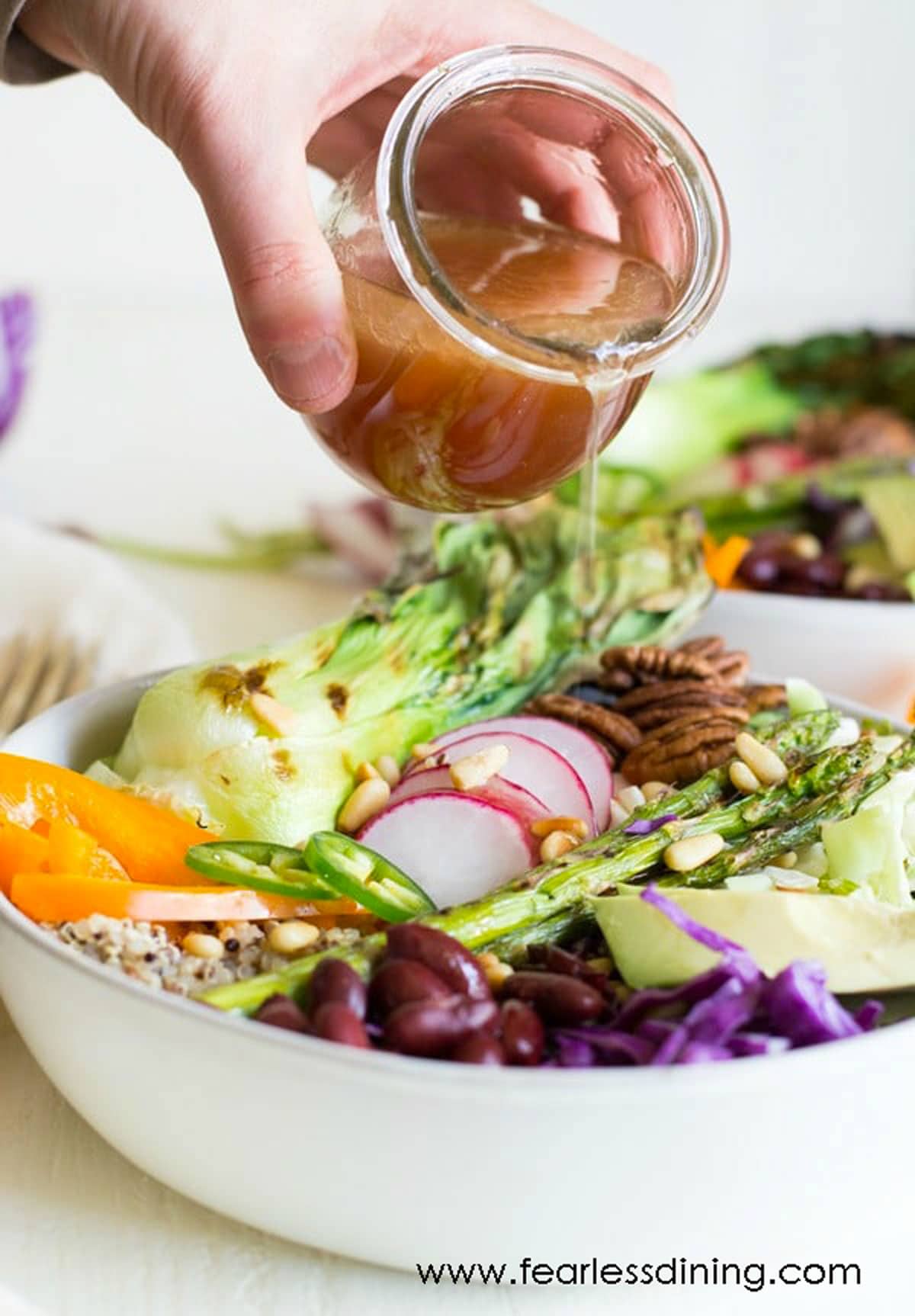 pouring dressing over the buddha bowl