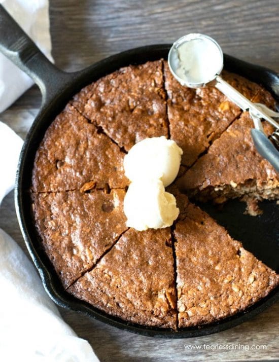 A giant oatmeal cookie that was baked in a cast iron skillet.
