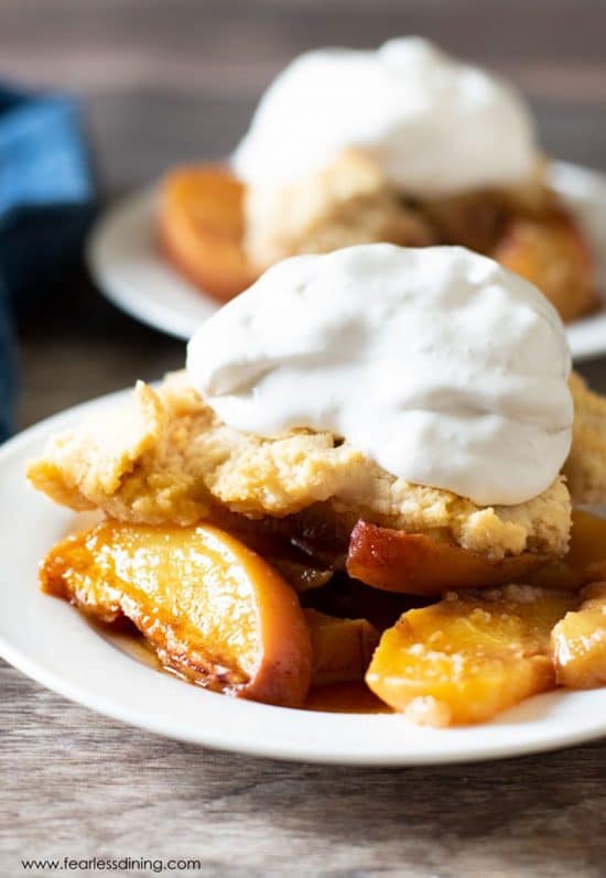 A serving of peach cobbler topped with whipped cream.