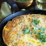 A cooked frittata in a cast iron skillet.