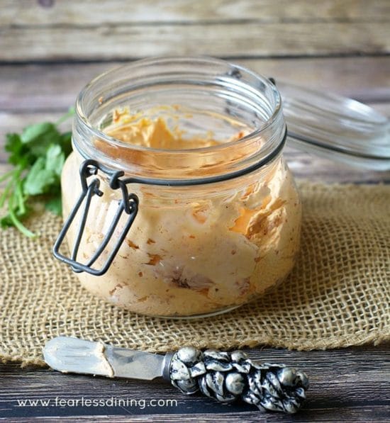 A small mason jar filled with roasted red pepper cream cheese spread.