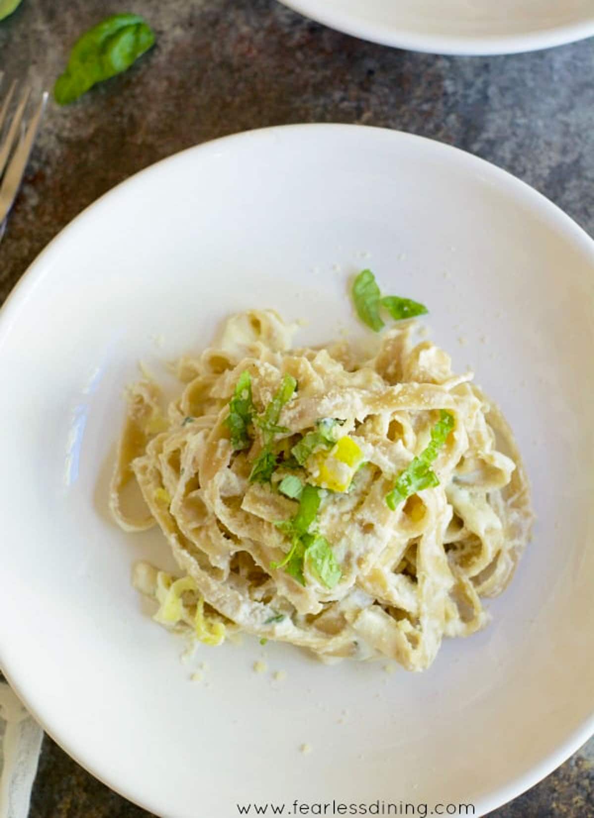 Looking down on a white plate filled with fettuccine alfredo.