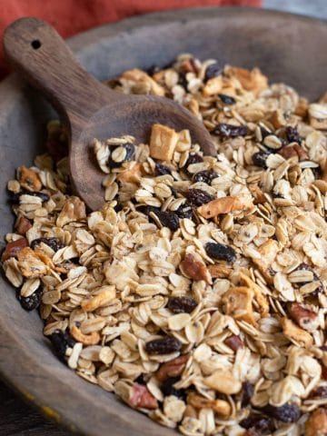 A wooden serving bowl filled with granola