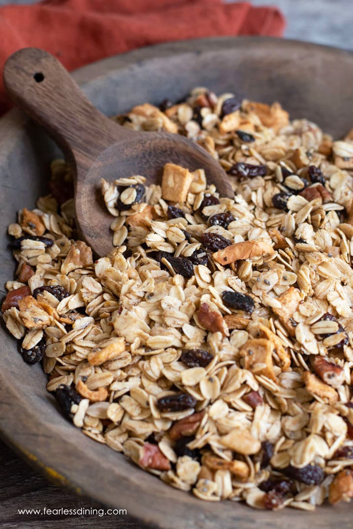 A wooden serving bowl filled with granola.