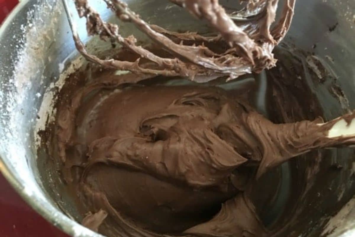 Chocolate buttercream frosting in a mixing bowl.