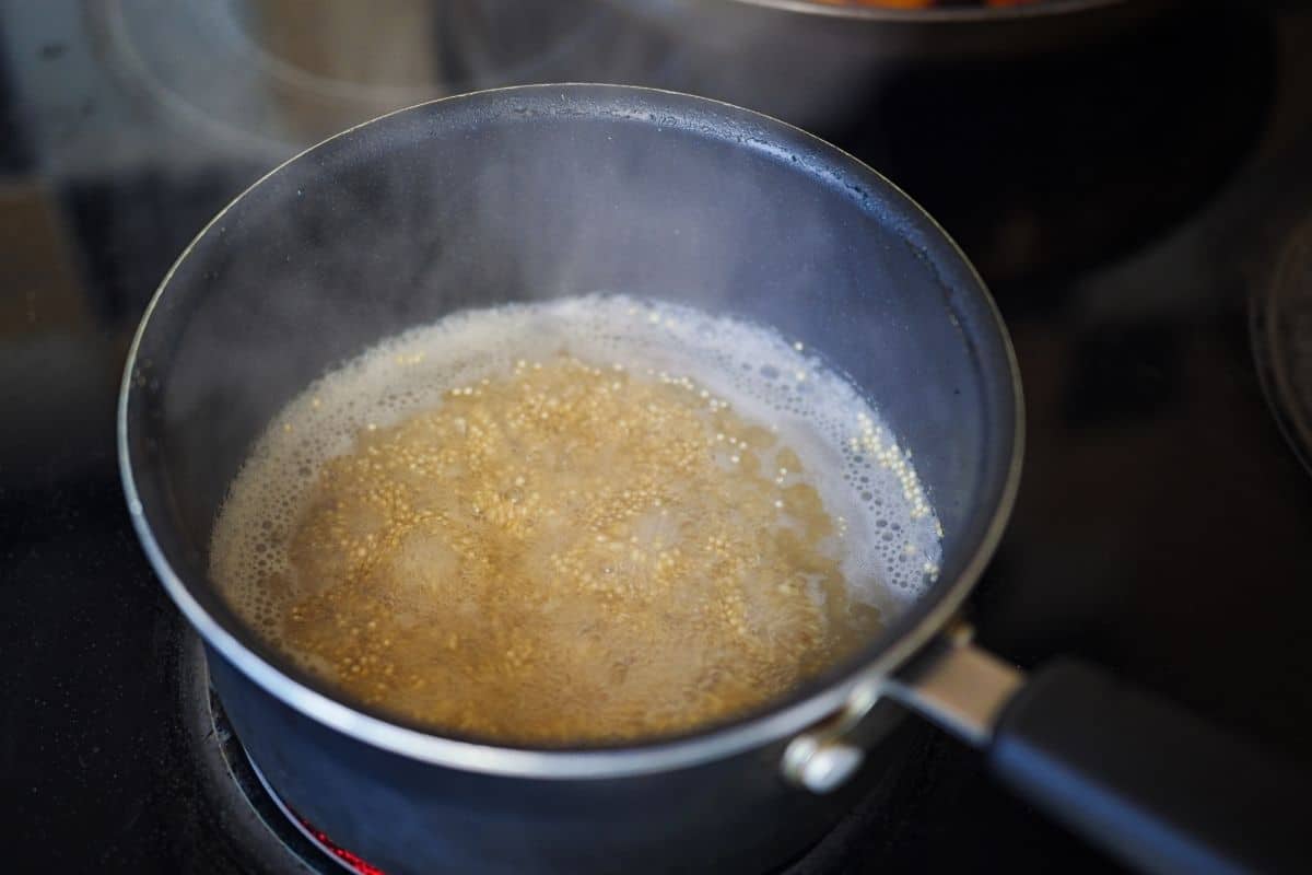 Quinoa cooking in a pot on the stove.