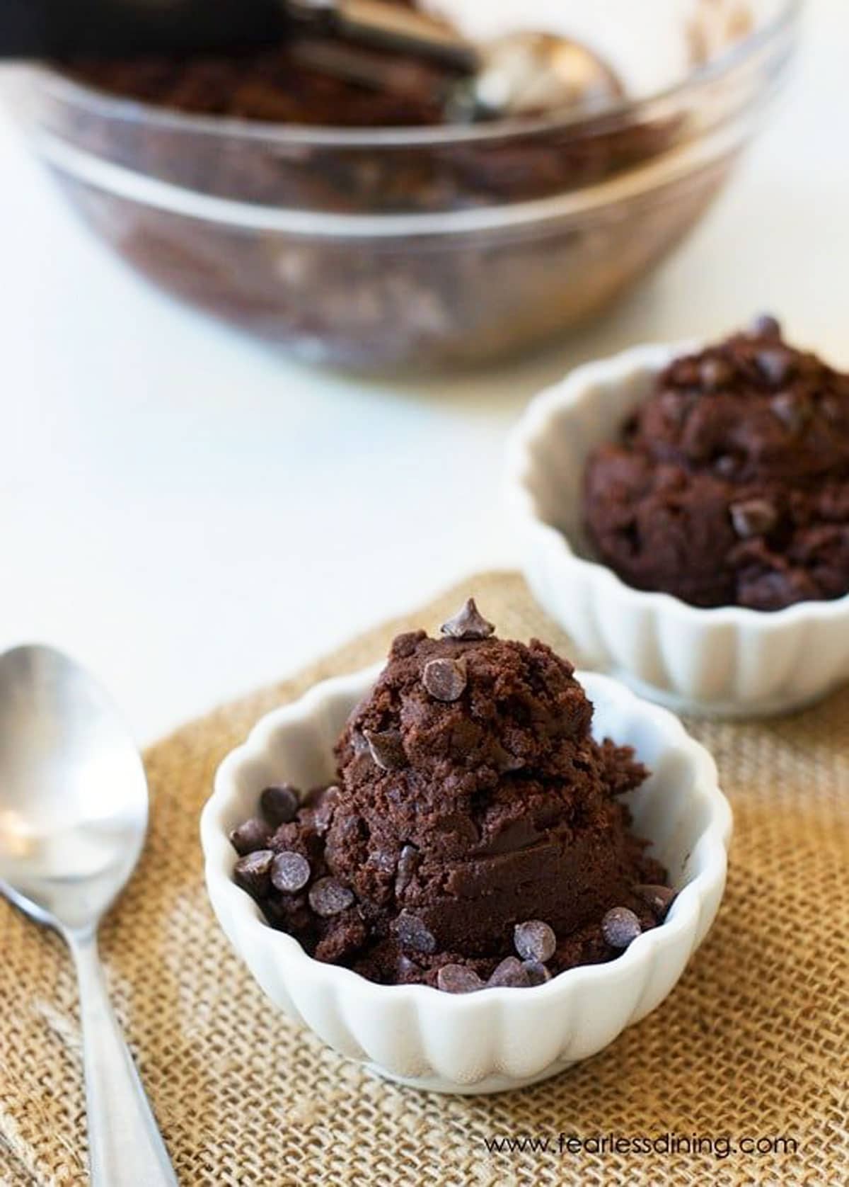 Two white bowls filled with chocolate cookie dough.