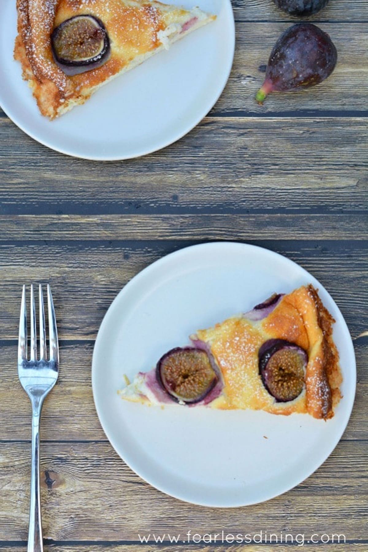 The top view of two slices of fig cake on white plates.