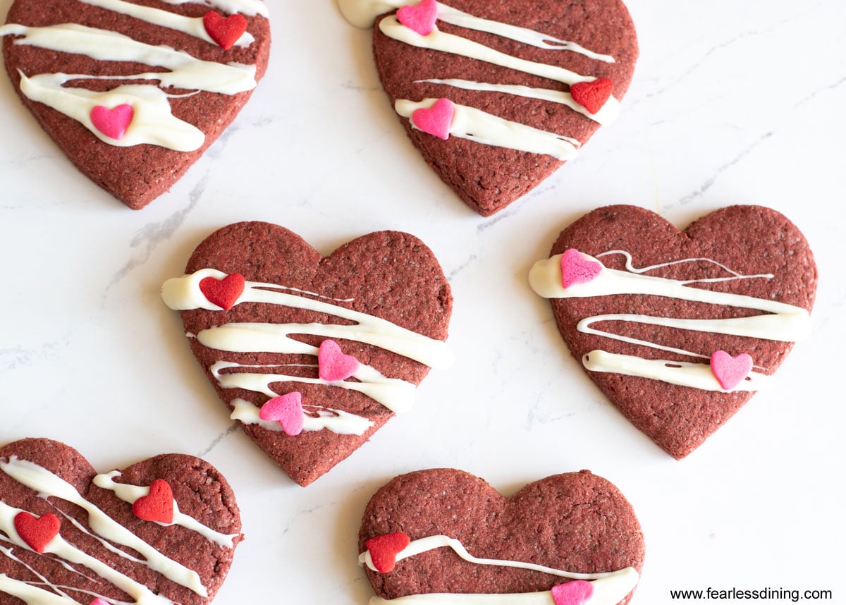 Decorated red velvet heart shaped cookies on a tray.