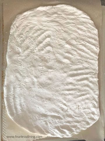 a pizza crust on a baking sheet