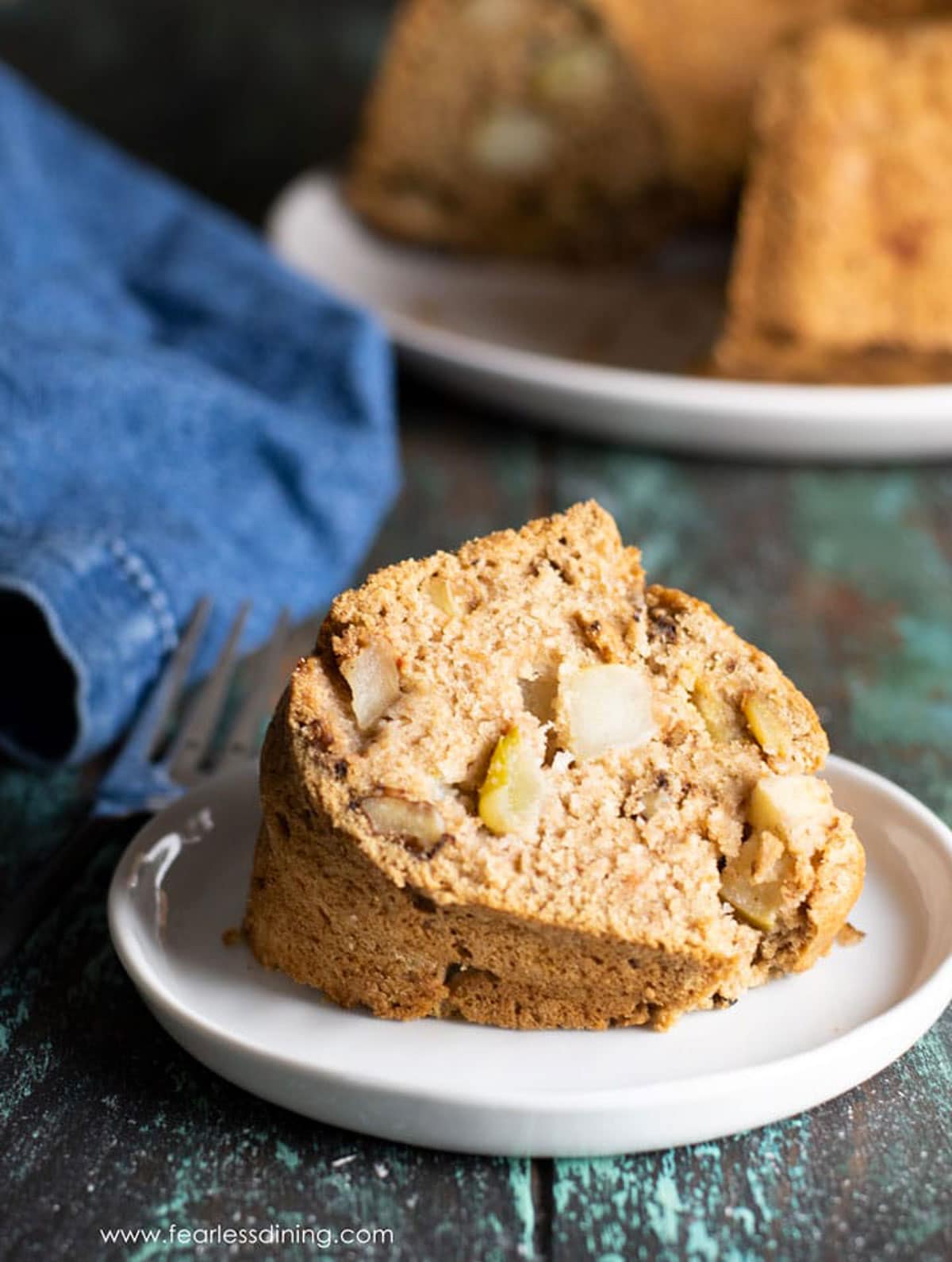 A slice of apple bundt cake on a small white plate.